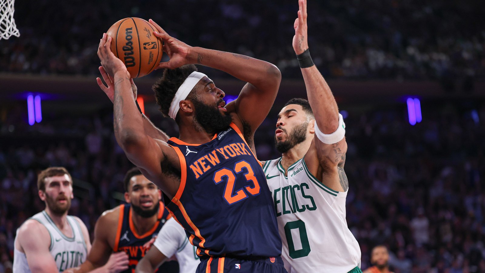 May 12, 2025; New York, New York, USA; New York Knicks center Mitchell Robinson (23) looks to pass after a rebound as Boston Celtics forward Jayson Tatum (0) defends in the first half during game four of the second round for the 2025 NBA Playoffs at Madison Square Garden.
