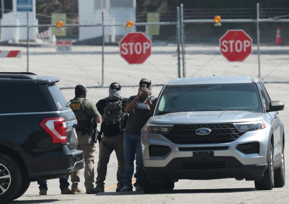 Federal agents stage stand outside Gate E of Dodger Stadium on Thursday.
