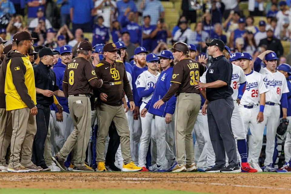 Padres and Dodgers players stand on the field after the benches clear in the ninth inning.
