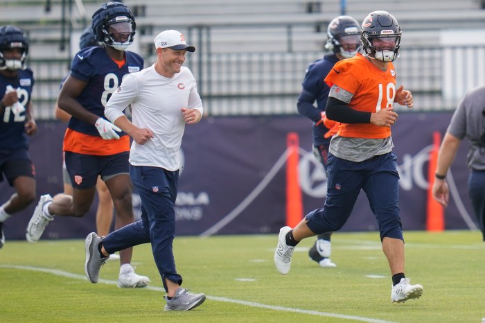 Ben Johnson smiles and runs with Caleb Williams during training camp