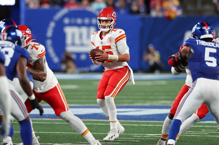 Patrick Mahomes stands in the pocket protected by his offensive lineman