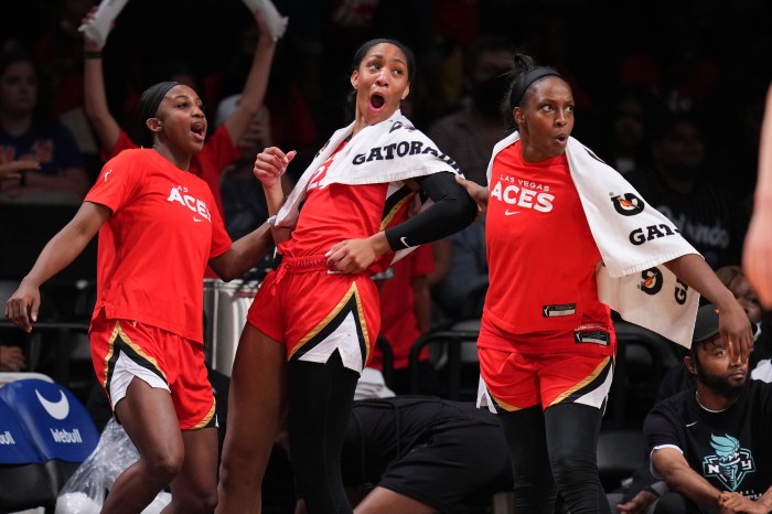 Jackie Young (from left), A'ja Wilson and Chelsea Gray of the Las Vegas Aces react from the bench during a game against the New York Liberty at Barclays Center on July 14, 2022, in Brooklyn, New York.