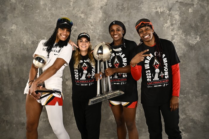 After winning the 2023 WNBA Finals, A'ja Wilson (from left), head coach Becky Hammon, Jackie Young and Chelsea Gray of the Las Vegas Aces pose with the championship trophy on Oct. 18, 2023, at Barclays Center in Brooklyn, New York.